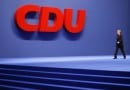 German Chancellor Merkel walks past a logo of the conservative CDU at the party congress in Hanover German Chancellor Merkel walks past a logo of the conservative CDU at the party congress in Hanover